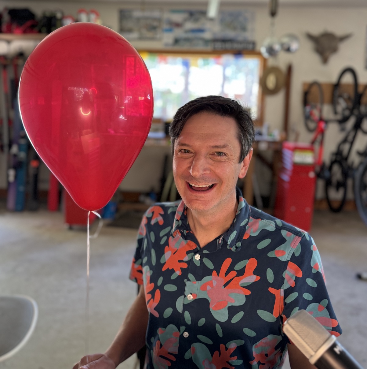 Robb holding a red balloon in his workshop to talk about The Game Changer